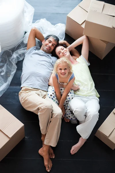 Parents and daughter on the floor with a lot of boxes — Stock Photo, Image