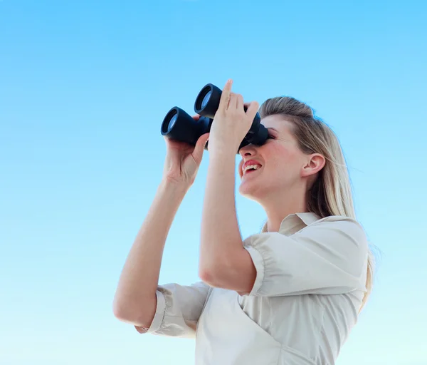 Blonde businesswoman looking through binoculars — Stock Photo, Image