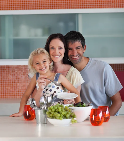 Sorrindo família comendo em uma cozinha — Fotografia de Stock