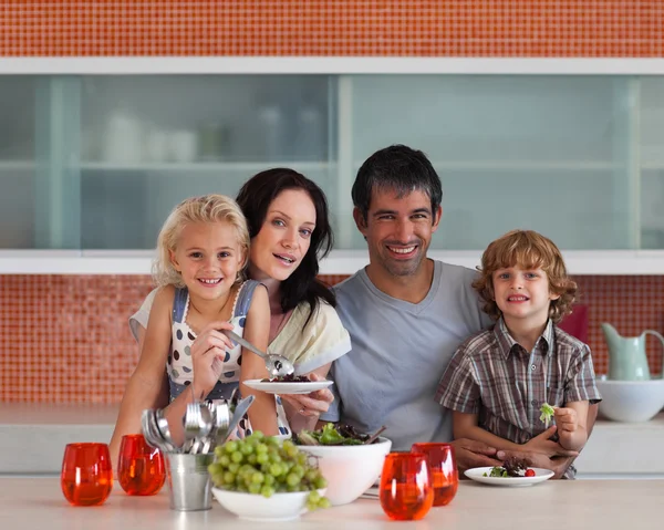 Happy family eating in a kitchen — Stock Photo, Image