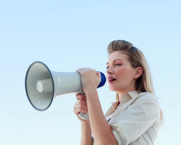 Блондинка-бизнесвумен кричит через мегафон — стоковое фото