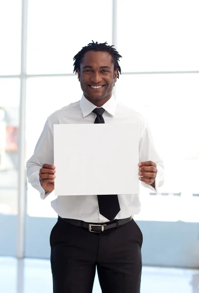 Empresário afro-americano sorridente segurando um cartão branco — Fotografia de Stock