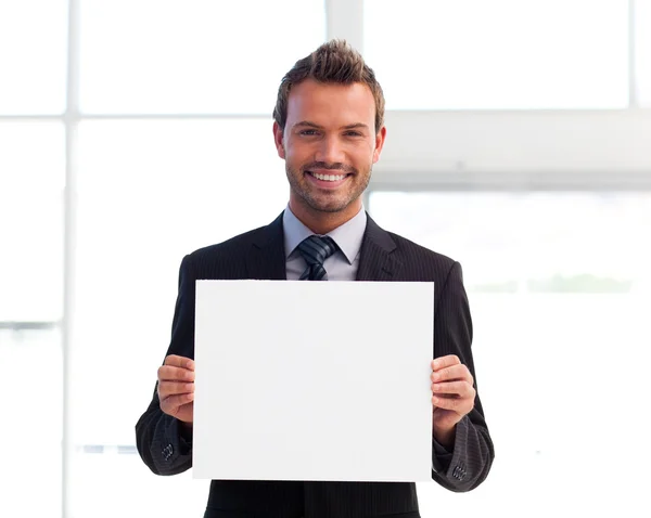 Usměvavý obchodník drží bílou kartu — Stock fotografie