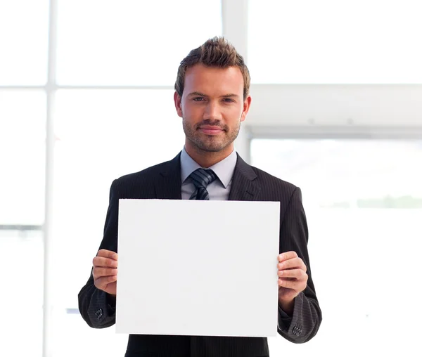 Serious businessman holding a white card — Stock Photo, Image