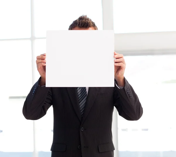 Empresario sosteniendo una tarjeta blanca delante de su cara —  Fotos de Stock