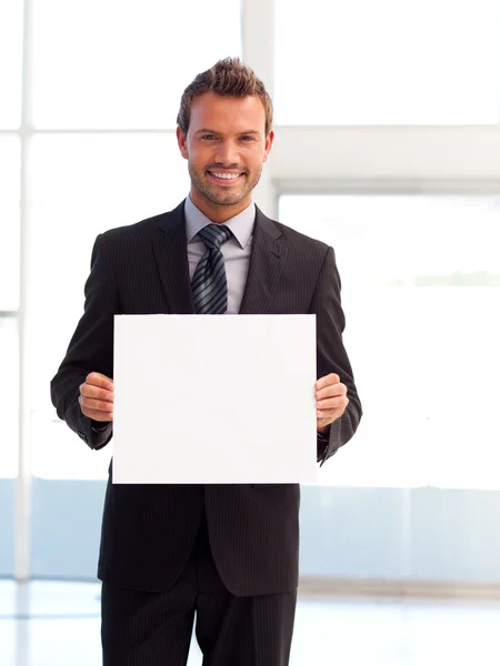Bonito homem de negócios sorrindo mostrando um cartão branco — Fotografia de Stock