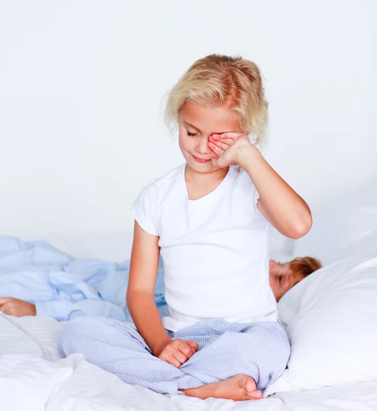 Portrait of a little girl waking up in a bedroom — Stock Photo, Image