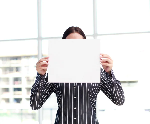 Leende kvinna visar ett stort visitkort framför hennes ansikte — Stockfoto