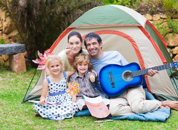 Family playing a guitar in a tent — Stock Photo, Image