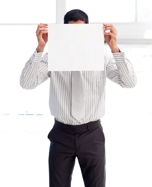 Empresario mostrando una tarjeta blanca cubriendo su cara — Foto de Stock