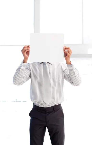 Empresário apresentando um cartão branco na frente de seu rosto — Fotografia de Stock