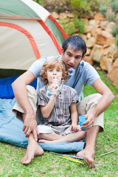 Father and son playing with bubbles — Stock Photo, Image