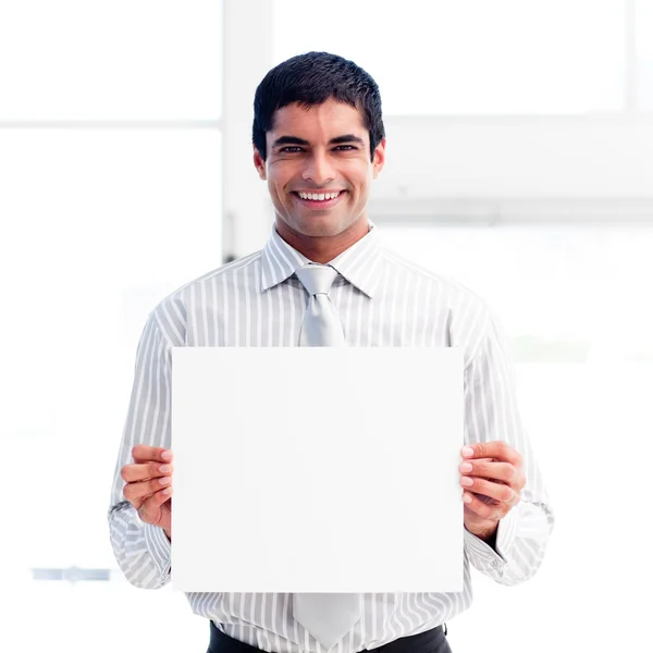 Retrato de um empresário sorridente segurando um cartão branco — Fotografia de Stock