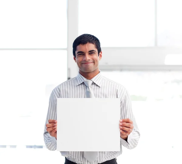 Empresário sorridente apresentando um cartão branco — Fotografia de Stock