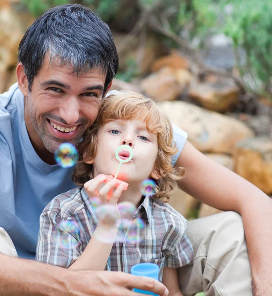Retrato de um pai e filho soprando bolhas — Fotografia de Stock