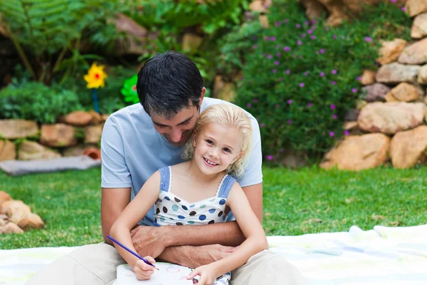 Padre e hija leyendo en un parque — Foto de Stock