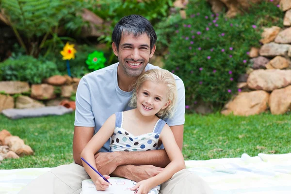 Father and daughter writing in a park — Stock Photo, Image