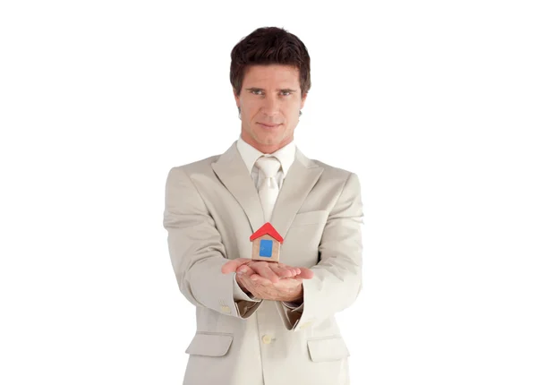 Un hombre de negocios guapo sosteniendo una casa — Foto de Stock