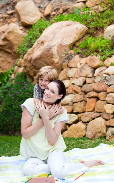 Syn obejmując jego matka w parku — Zdjęcie stockowe