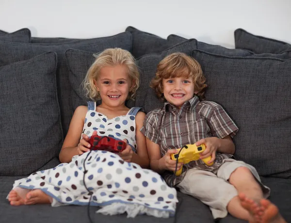 Bambini allegri che giocano ai videogiochi a casa — Foto Stock