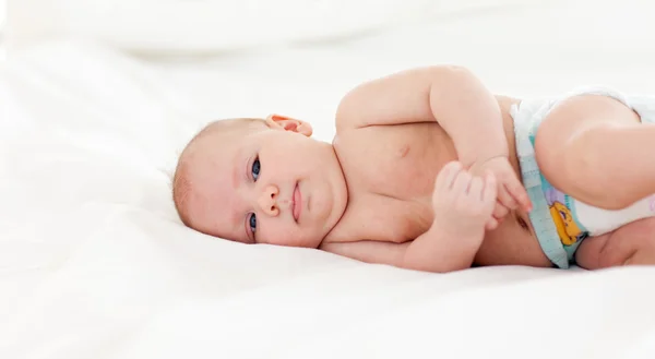 Baby liggend in bed — Stockfoto