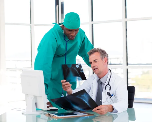 Two doctors talking about two x-rays — Stock Photo, Image