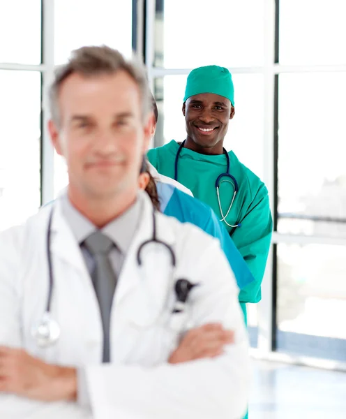 Lachende chirurg met gevouwen armen in een lijn — Stockfoto