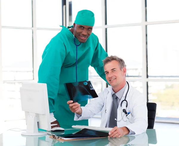 Ανώτερος γιατρός και νεαρή χειρουργός μελετώντας μια ακτινογραφία — Φωτογραφία Αρχείου
