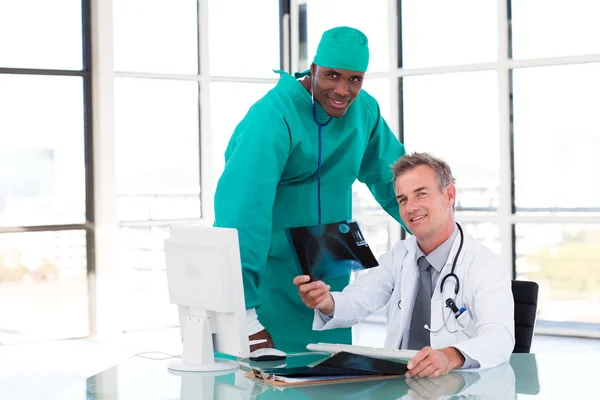 Доктор и хирург смотрят на рентген — стоковое фото