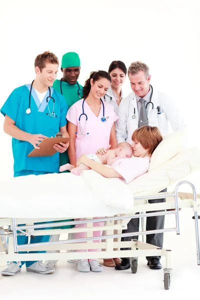 Médicos que atendem uma mãe e seu bebê recém-nascido — Fotografia de Stock