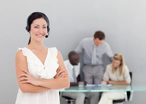 Businesswoman talking on a headset with folded arms — Stock Photo, Image