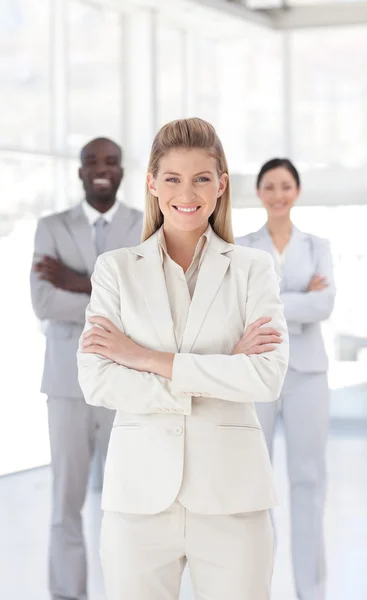 Retrato de uma mulher de negócios séria em pé com seus colegas — Fotografia de Stock