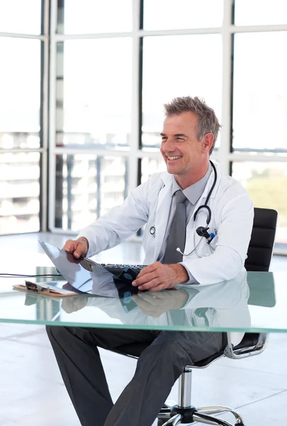 Porträt eines hansdome-Arztes bei der Untersuchung eines Röntgenbildes an seinem Schreibtisch — Stockfoto
