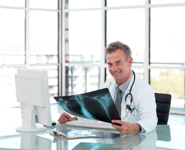 Портрет врача, осматривающего рентген за своим столом — стоковое фото