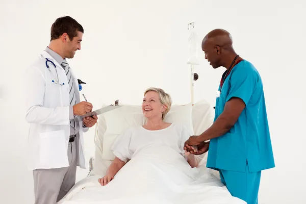 Team av läkare undersöka en patient — Stockfoto