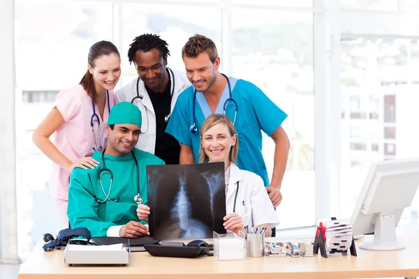 Enfermera, doctores y cirujano examinando una radiografía — Foto de Stock