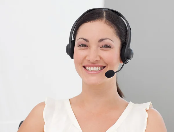 Mulher de negócios internacional bonita em um fone de ouvido sorrindo — Fotografia de Stock