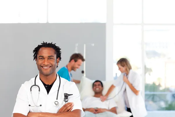 Afrikanska läkare med sina kolleger i bakgrunden med kopia-s — Stockfoto