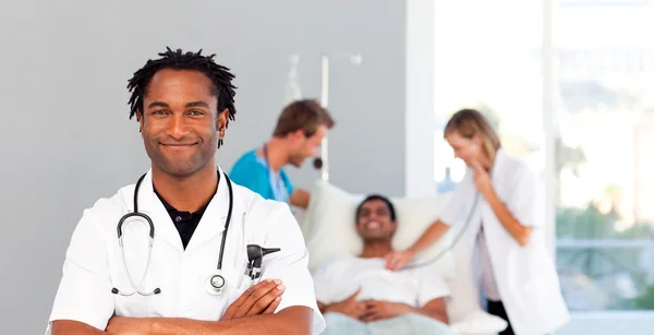 Portrait of an African doctor with a patient in the background — Stock Photo, Image