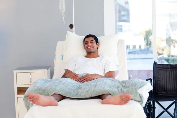 Paciente hispânico na cama sorrindo para a câmera — Fotografia de Stock