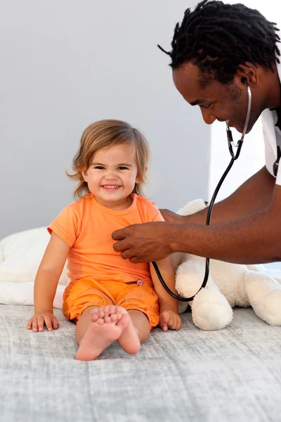 Barns läkare examen en liten flicka med stetoskop — Stockfoto
