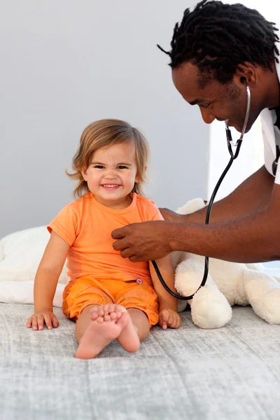 Médico de niños examina a una niña con estetoscopio —  Fotos de Stock