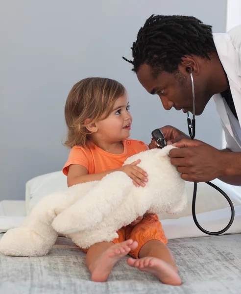 Дитячий лікар оглядає маленьку дівчинку зі стетоскопом — стокове фото