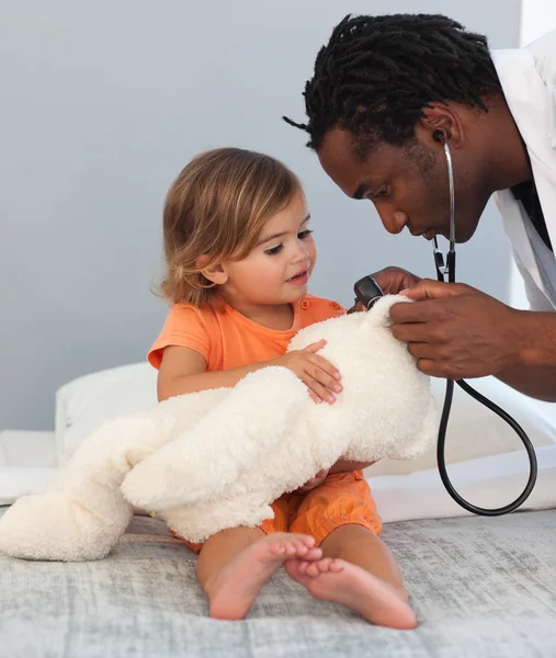 Дитячий лікар оглядає маленьку дівчинку зі стетоскопом — стокове фото