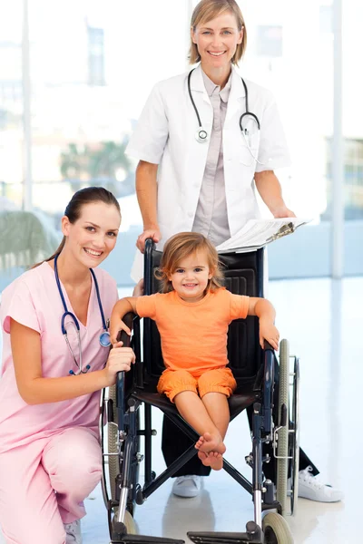 Kameraya bakarak bir tekerlekli sandalye doktorlar, küçük kız — Stok fotoğraf