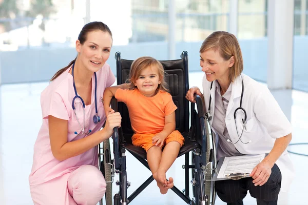 Petite fille en fauteuil roulant avec infirmière et médecin — Photo