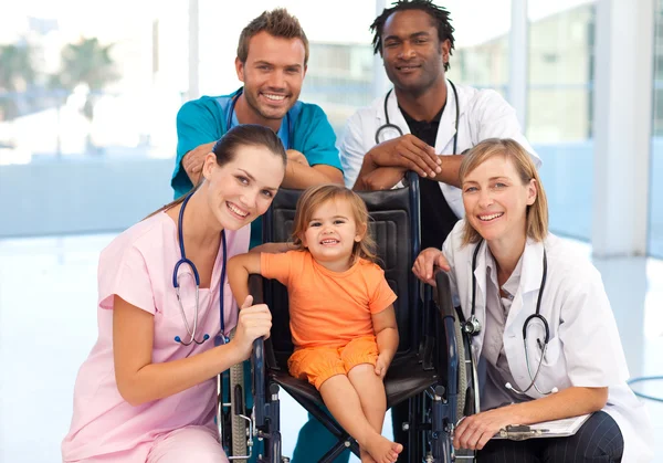 组的一个小女孩坐在轮椅上的医生 — 图库照片