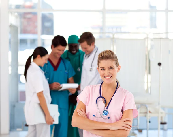 Enfermera con médicos en segundo plano —  Fotos de Stock