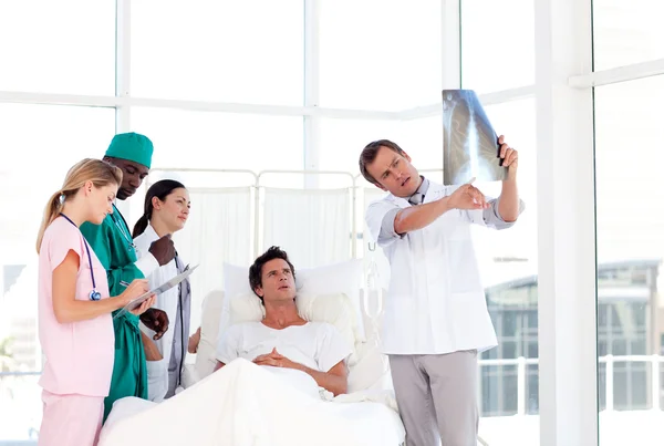 Doctor showing an X-ray to his patient — Stock Photo, Image