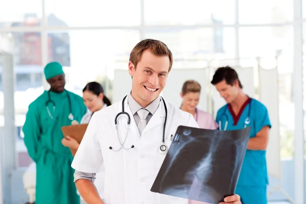 Doctor with colleagues in the background — Stock Photo, Image